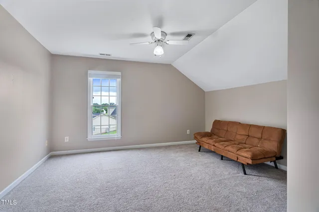 an empty room with windows and ceiling fan