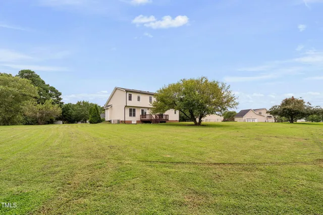 a view of a house with yard and large trees