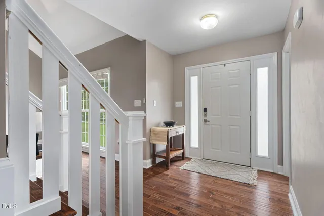 a view of an entryway with wooden floor and livingroom