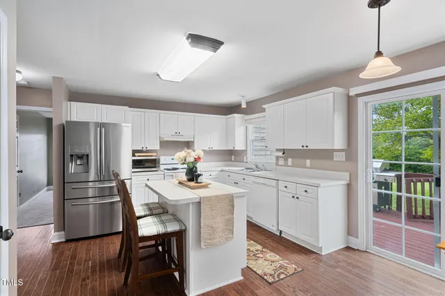 a kitchen with refrigerator cabinets dining table and chairs