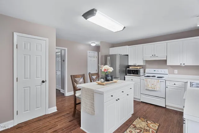 a kitchen with white cabinets and white appliances