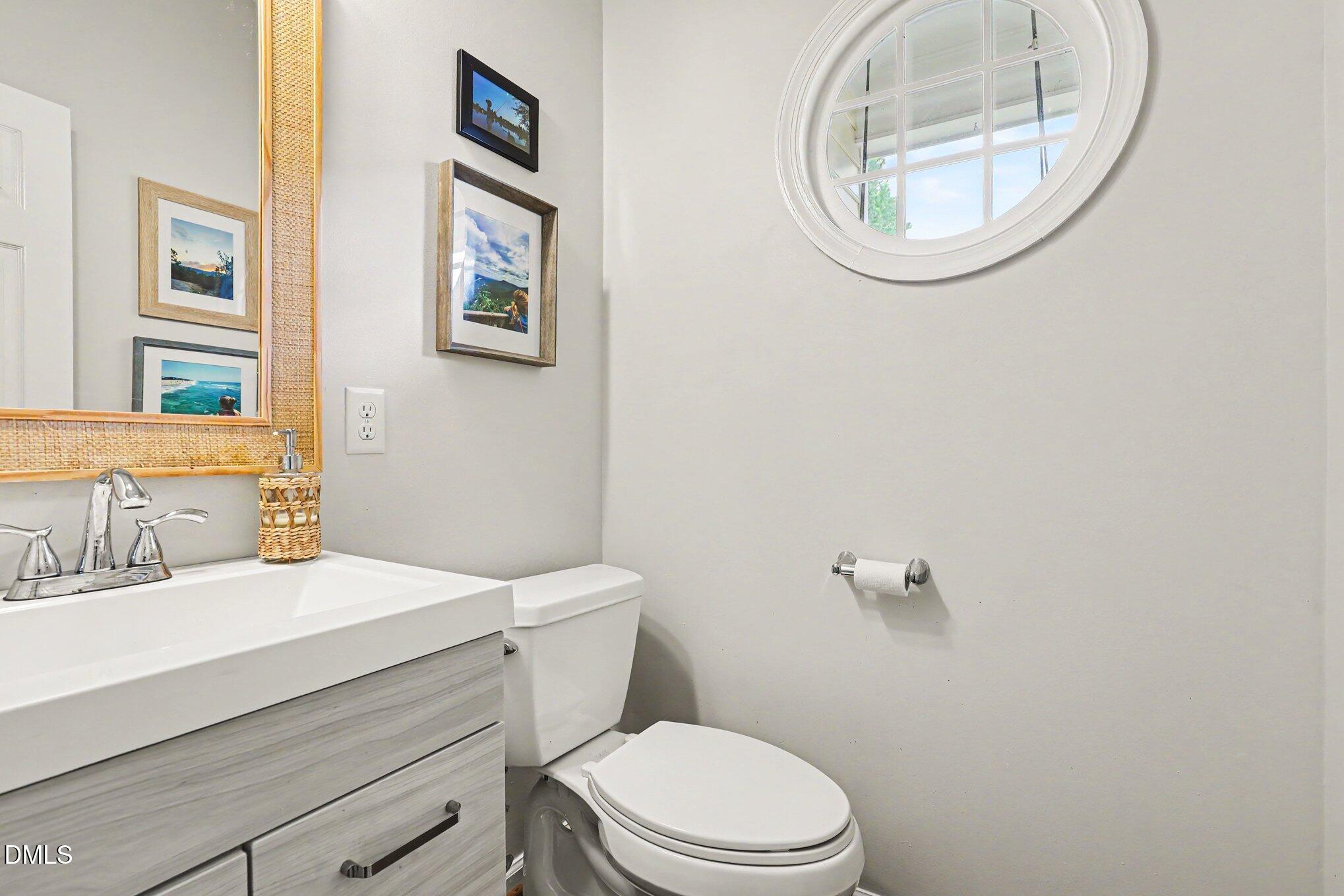 5468 Ingate Way Raleigh, NC 27613 - Photo 4 of 24 a bathroom with a sink mirror and toilet