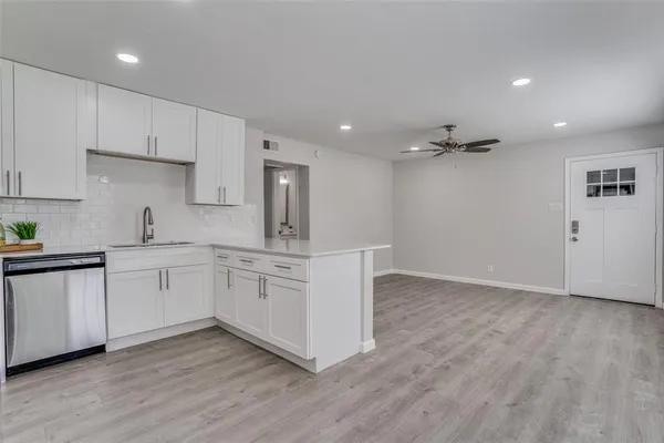 a kitchen with cabinets wooden floor and appliances