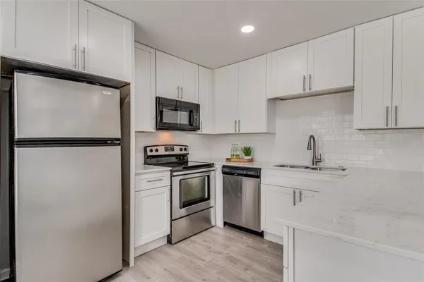 a kitchen with cabinets stainless steel appliances and a counter space