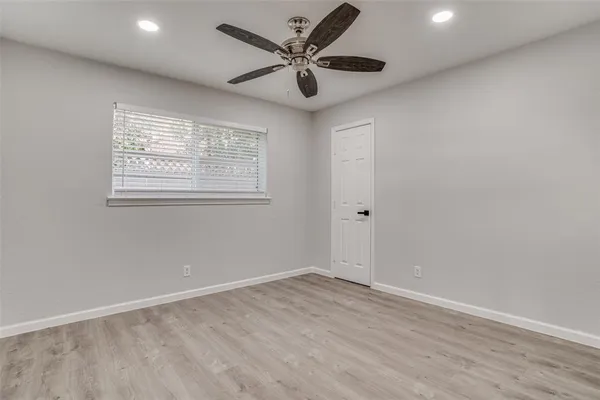 an empty room with a window and a fan
