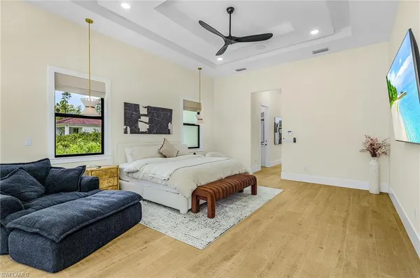 a spacious bedroom with a bed a couch and a flat screen tv