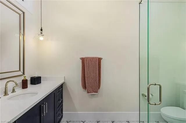 a bathroom with a granite countertop sink vanity mirror and toilet