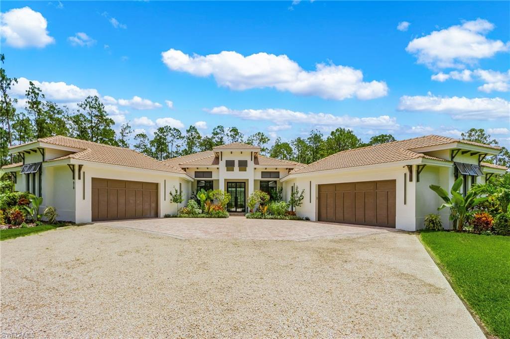 618 31st Street Northwest Naples, FL 34117 - Photo 3 of 47 a front view of a house with a garden and mountain view