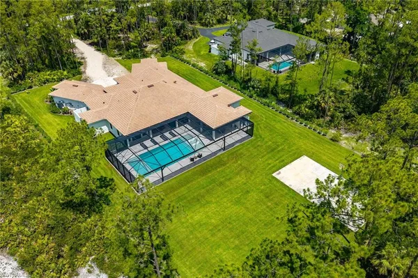 an aerial view of a house with pool yard and outdoor seating