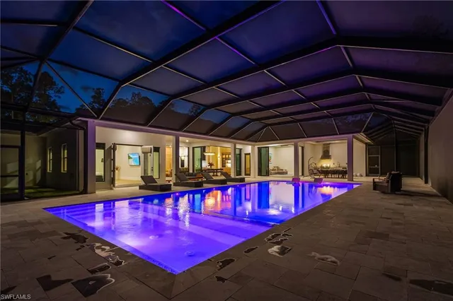 a view of a pool with red chairs