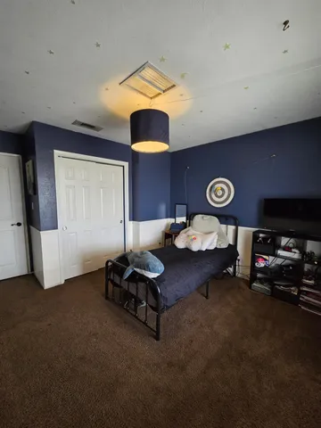 a bedroom with a bed and flat screen tv