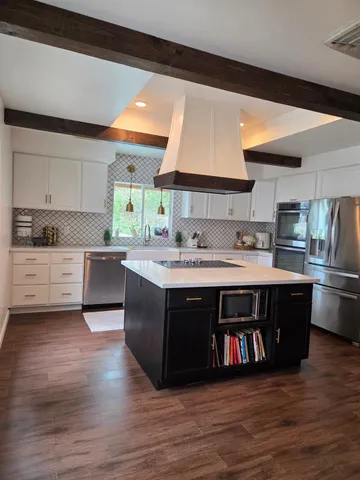 a kitchen with cabinets and wooden floor