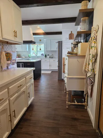 a kitchen with stainless steel appliances granite countertop a table chairs stove and wooden floor