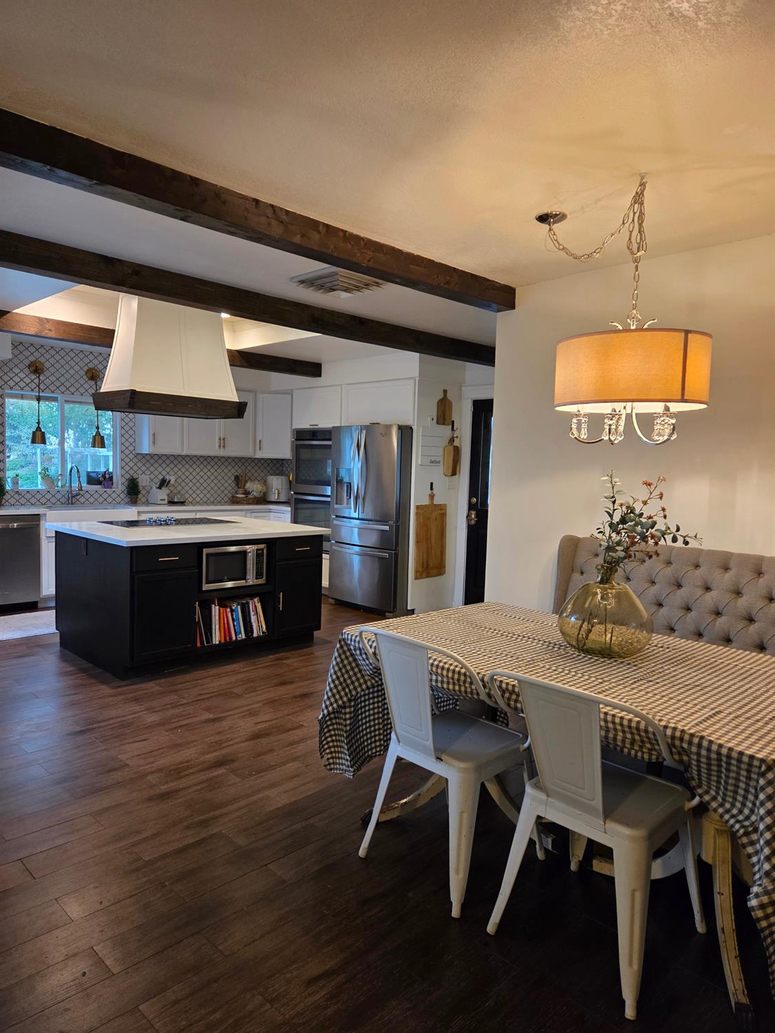 22849 East Jefferson Avenue Reedley, CA 93654 - Photo 7 of 31 a kitchen with stainless steel appliances granite countertop a table chairs stove and wooden floor
