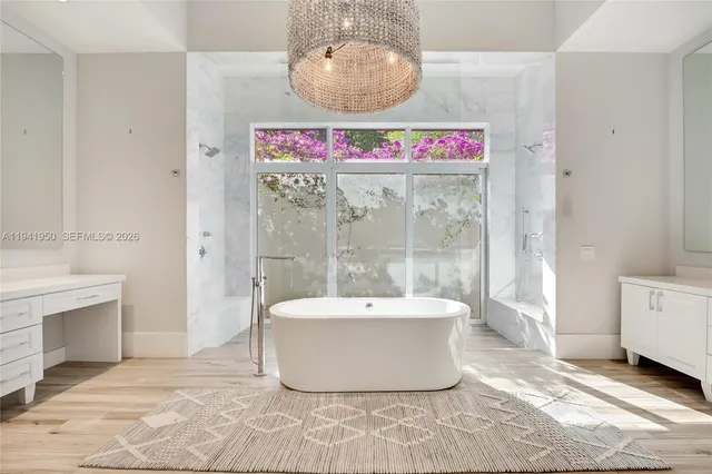 a bathroom with a tub sink shower and mirror