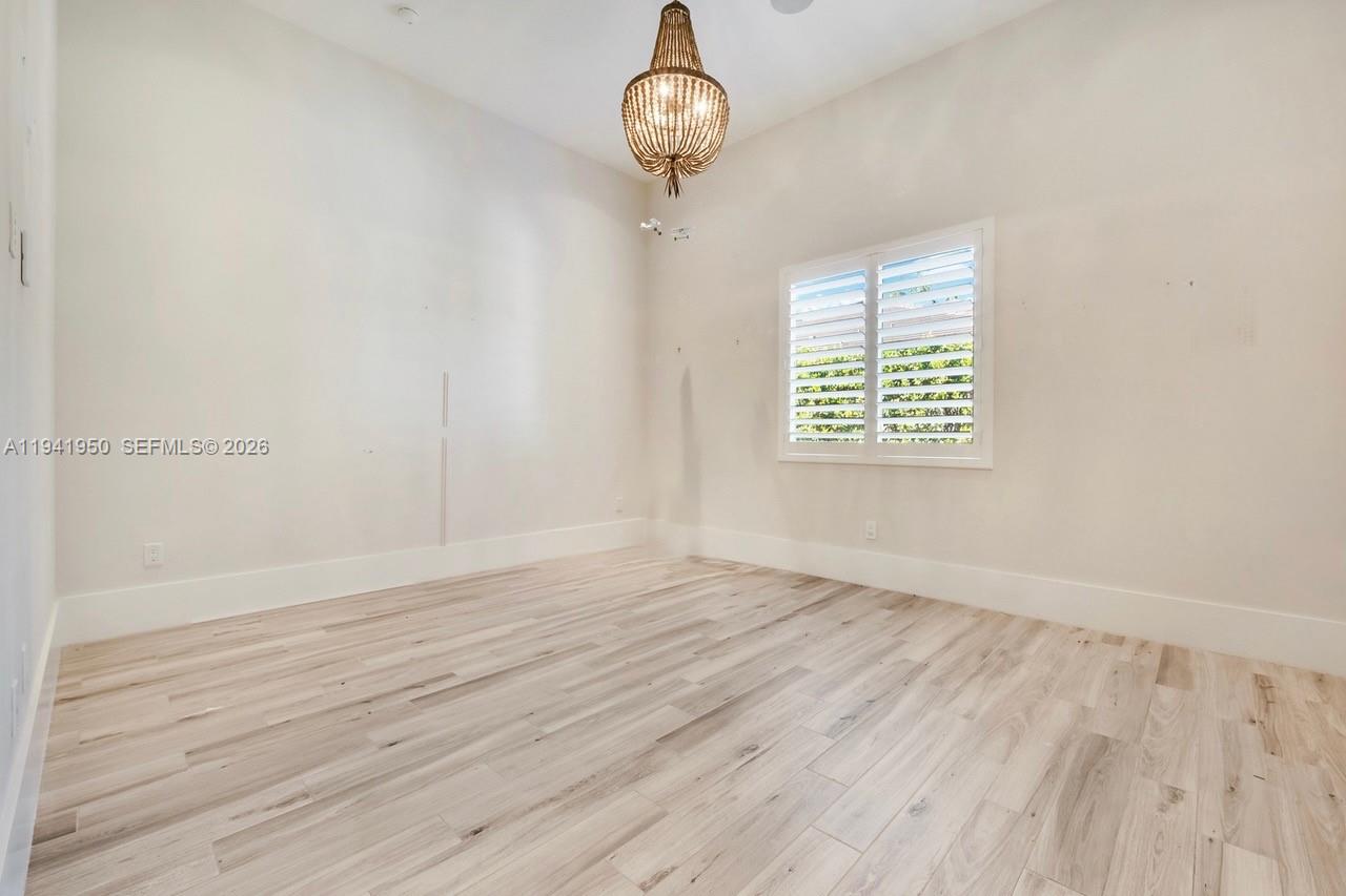 6880 Southwest 82nd Avenue Miami, FL 33143 - Photo 17 of 29 a view of an empty room with wooden floor and a window