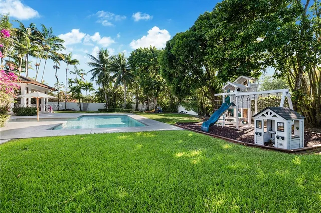 a view of house with garden and swimming pool
