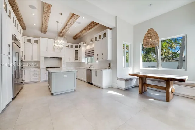 a large living room with stainless steel appliances kitchen island granite countertop furniture and a large window