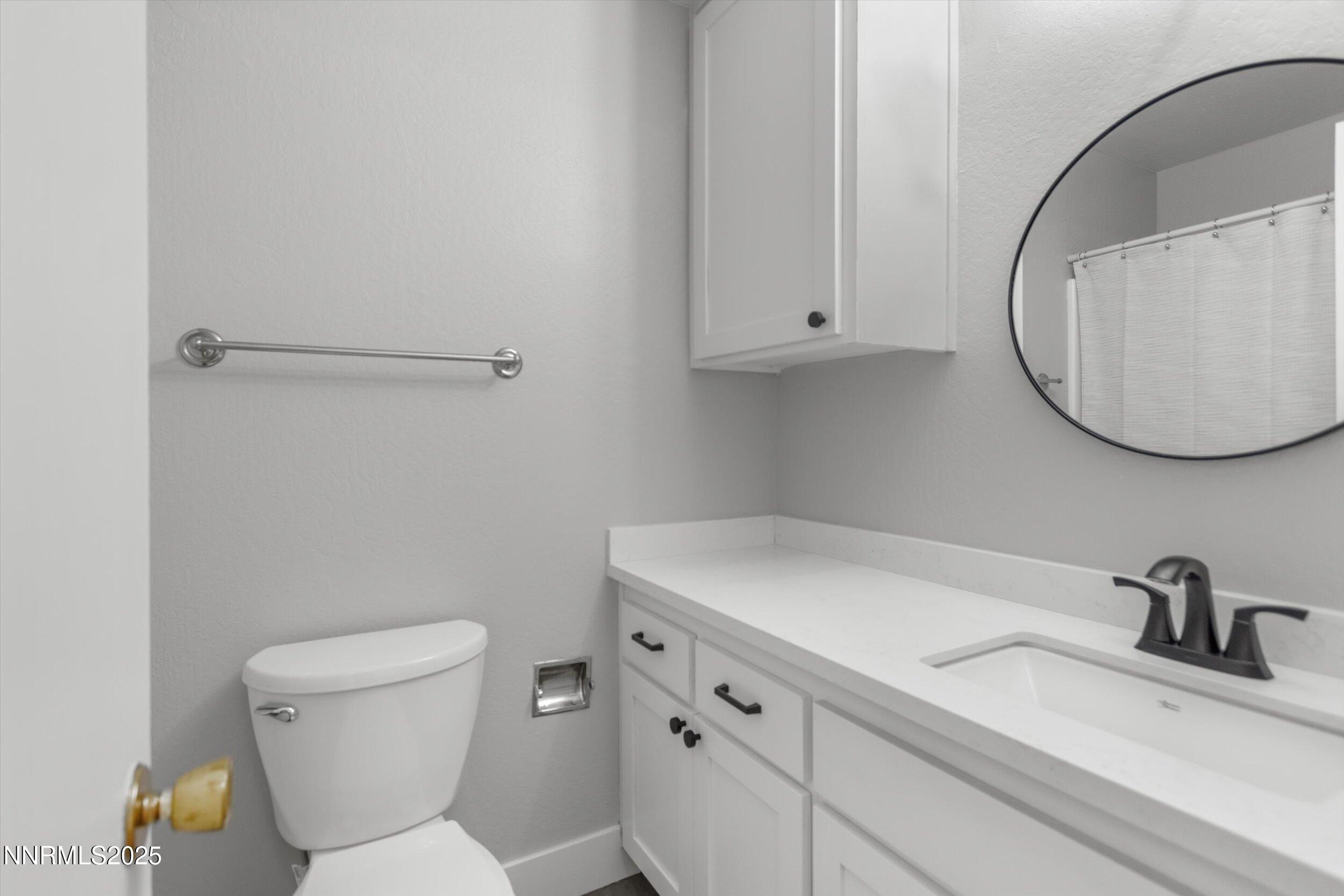 4634 Rio Poco Road Reno, NV 89502 - Photo 14 of 24 a bathroom with a sink toilet and a mirror