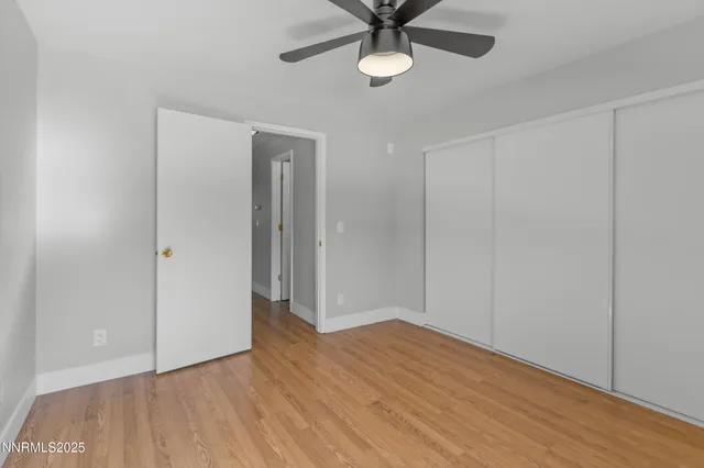 a view of a hallway with wooden floor and door