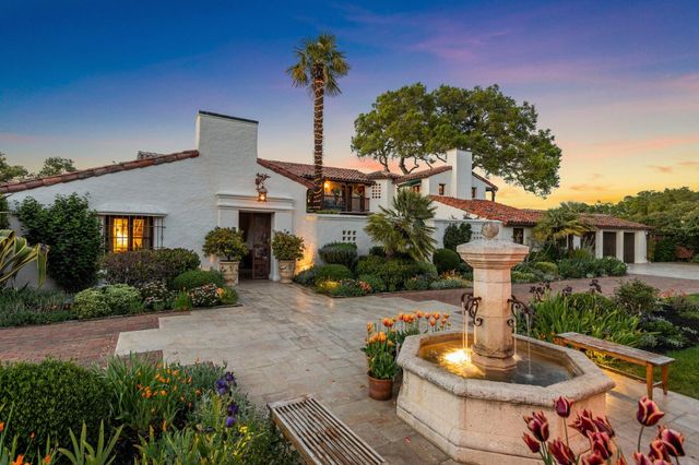 a front view of a house with a yard and potted plants