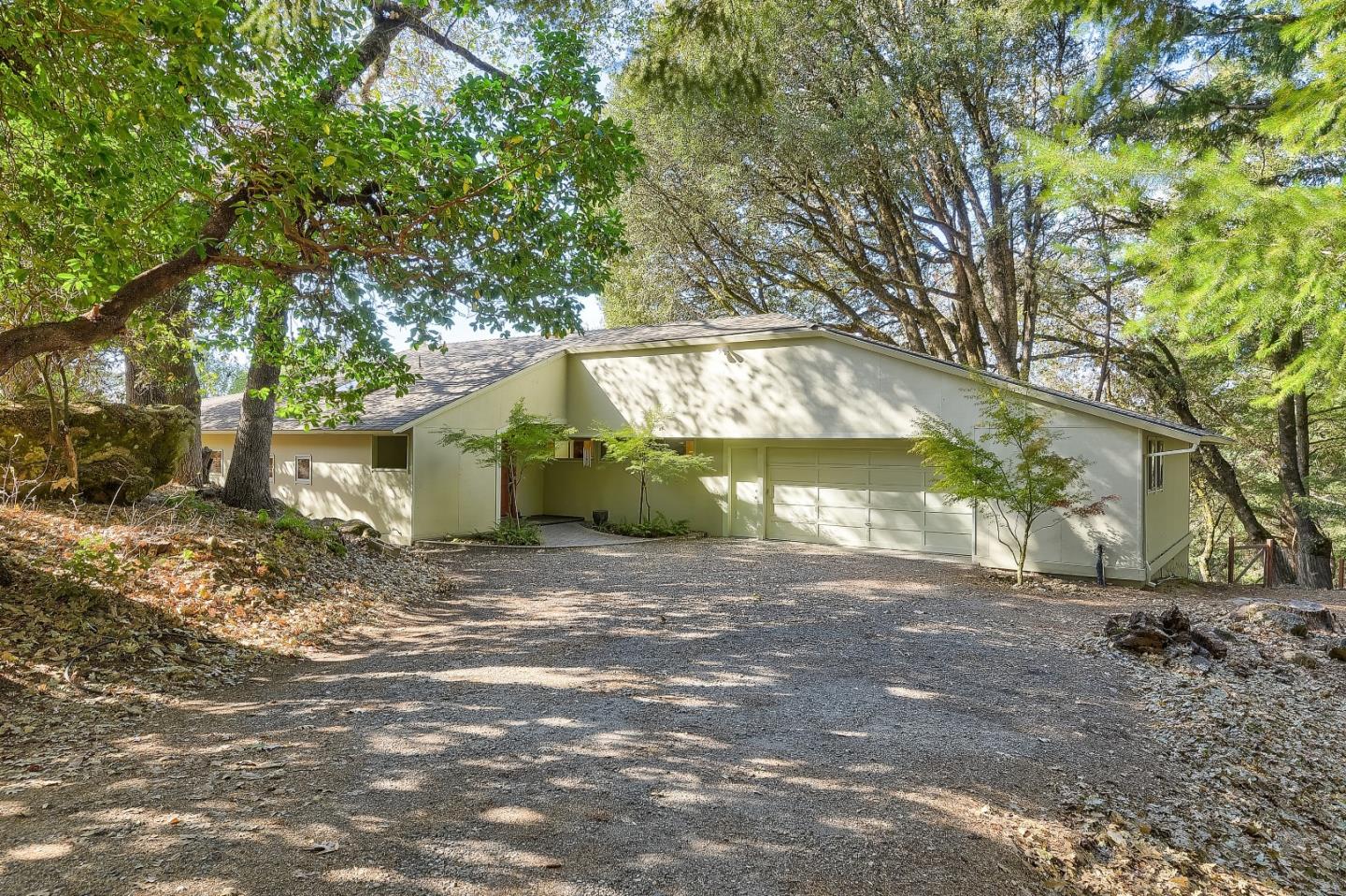 a view of a house with a yard and large tree