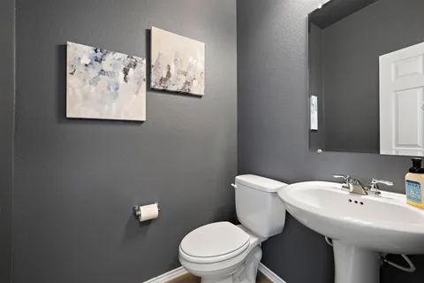 a bathroom with a toilet a sink and mirror