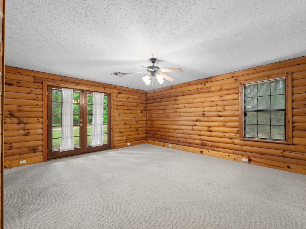 12868 Levi Road Willis, TX 77378 - Photo 19 of 41 Spacious primary bedroom with warm wood accents, abundant natural light, and private outdoor access.