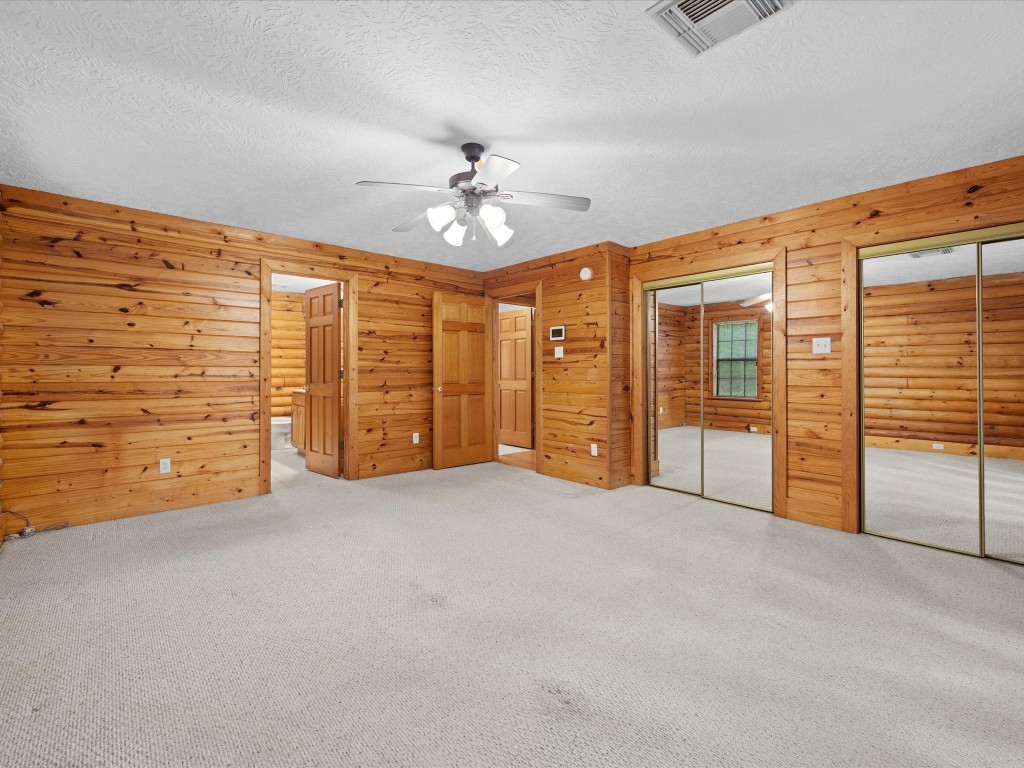 12868 Levi Road Willis, TX 77378 - Photo 6 of 41 Generous primary suite featuring dual closets, warm wood finishes, and a spacious, comfortable layout.