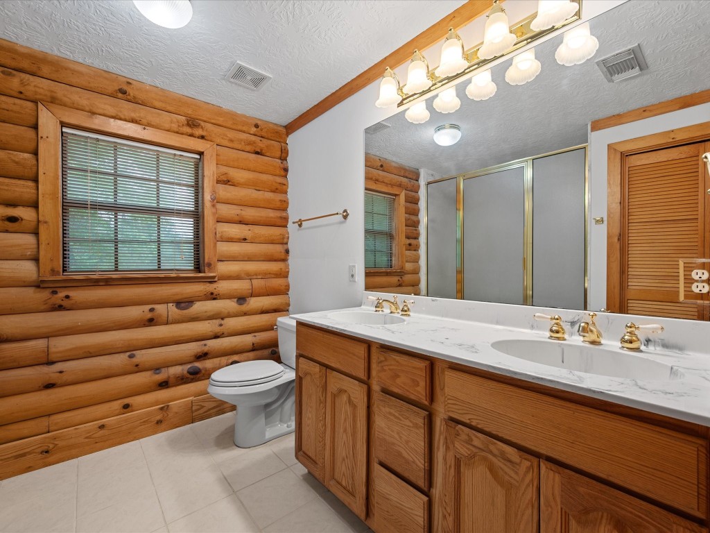 12868 Levi Road Willis, TX 77378 - Photo 7 of 41 Spacious primary bath featuring dual vanities, warm wood cabinetry, and a functional layout for everyday comfort.