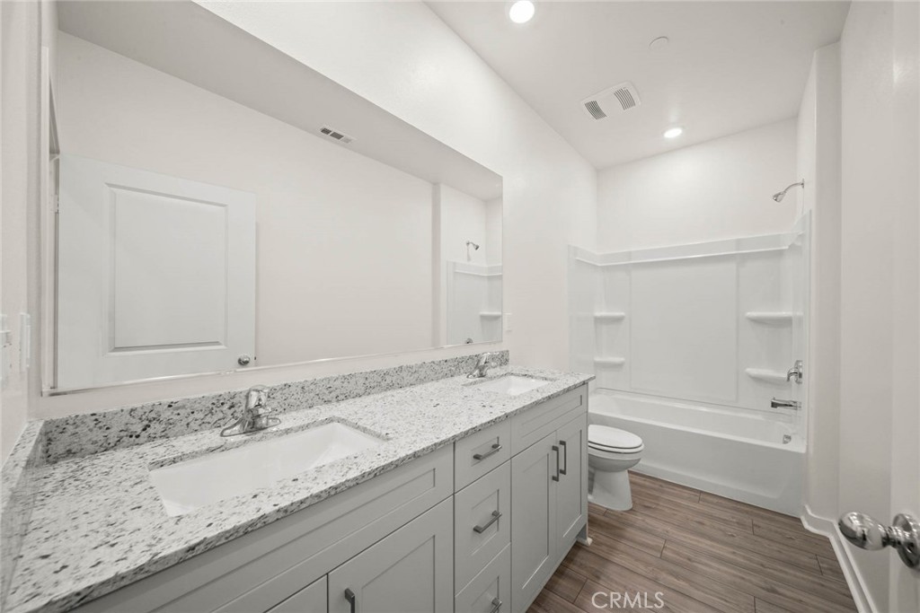 80523 Anacapa Drive Indio, CA 92201 - Photo 13 of 17 a bathroom with a granite countertop sink a toilet and bathtub