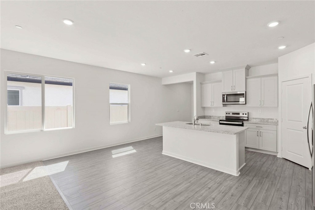 80523 Anacapa Drive Indio, CA 92201 - Photo 9 of 17 a kitchen with stainless steel appliances kitchen island wooden floors and white walls