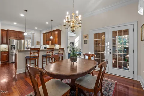 a dining room with furniture a chandelier and wooden floor