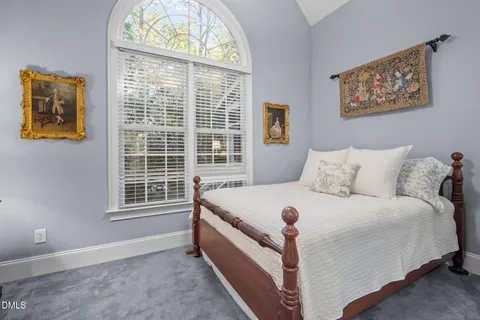 a large bed sitting in a bedroom next to a window