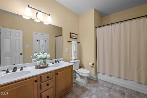 a bathroom with a double vanity sink a toilet and a mirror