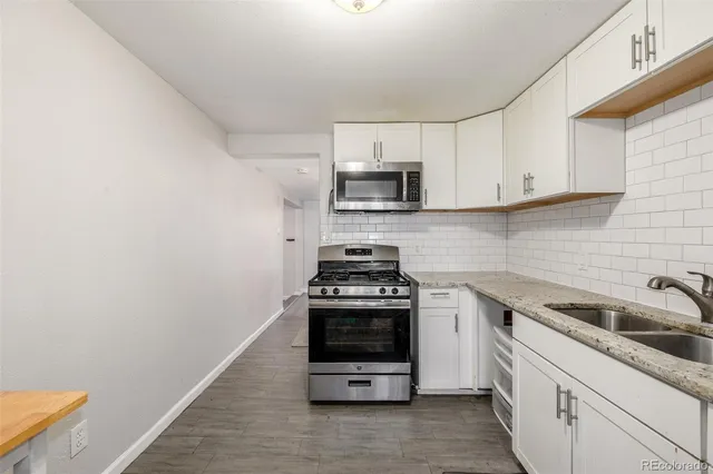 a kitchen with sink a stove and cabinets