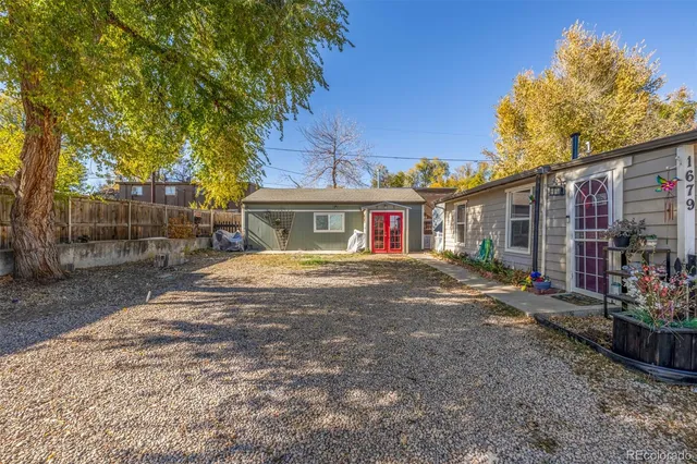 a view of a white house with a yard and plants