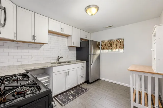 a kitchen with stainless steel appliances granite countertop a stove and a refrigerator