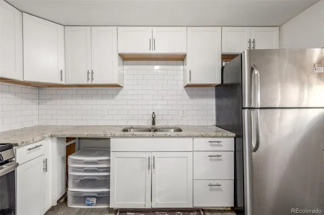 a kitchen with a sink a refrigerator and cabinets