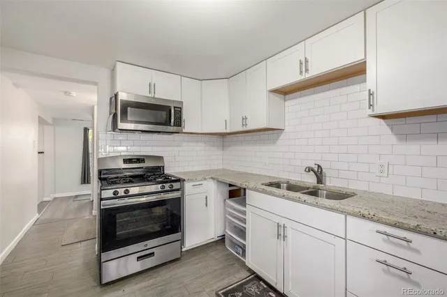 a kitchen with white cabinets stainless steel appliances and sink