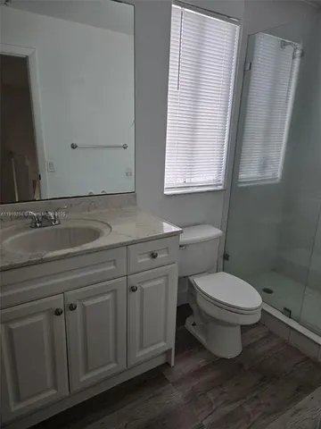 a bathroom with a granite countertop toilet sink and mirror