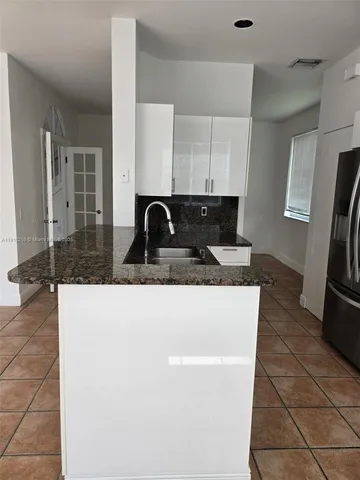 a kitchen with granite countertop a sink and a stove top oven