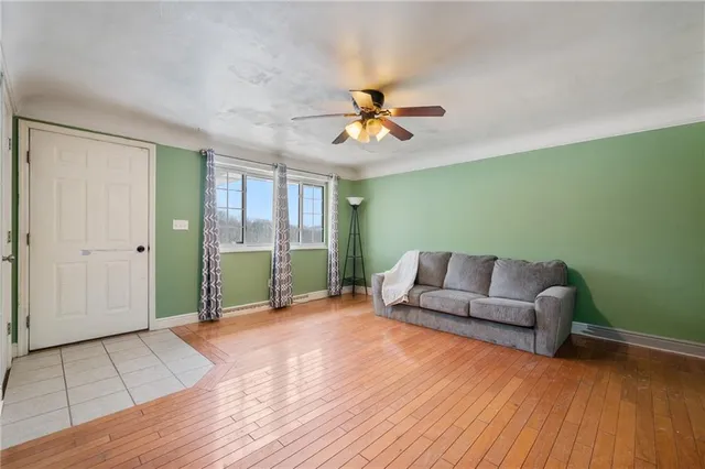 a view of a livingroom with wooden floor and a ceiling fan
