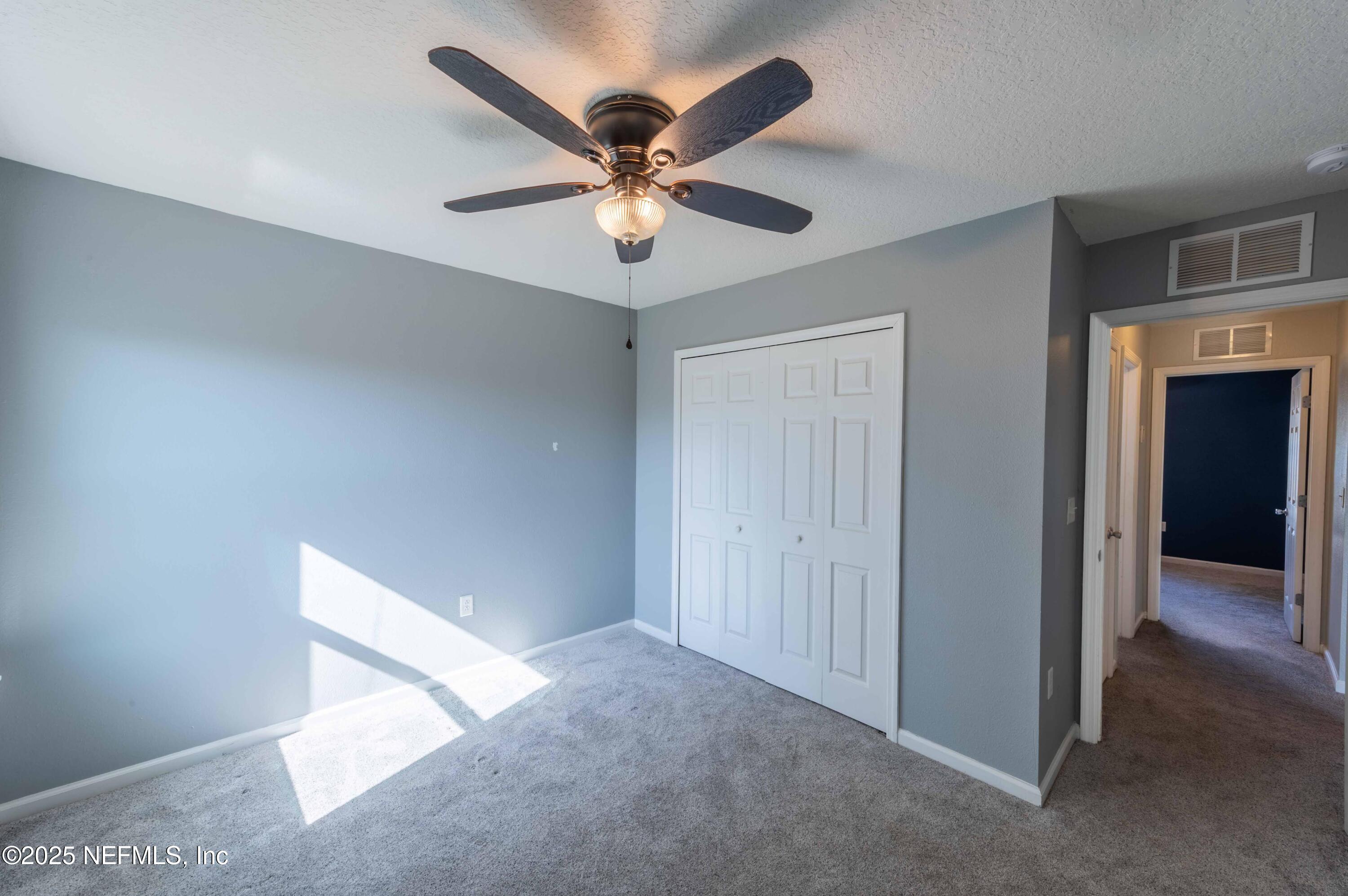 77041 Cobblestone Drive Yulee, FL 32097 - Photo 16 of 23 a view of an empty room with a ceiling fan