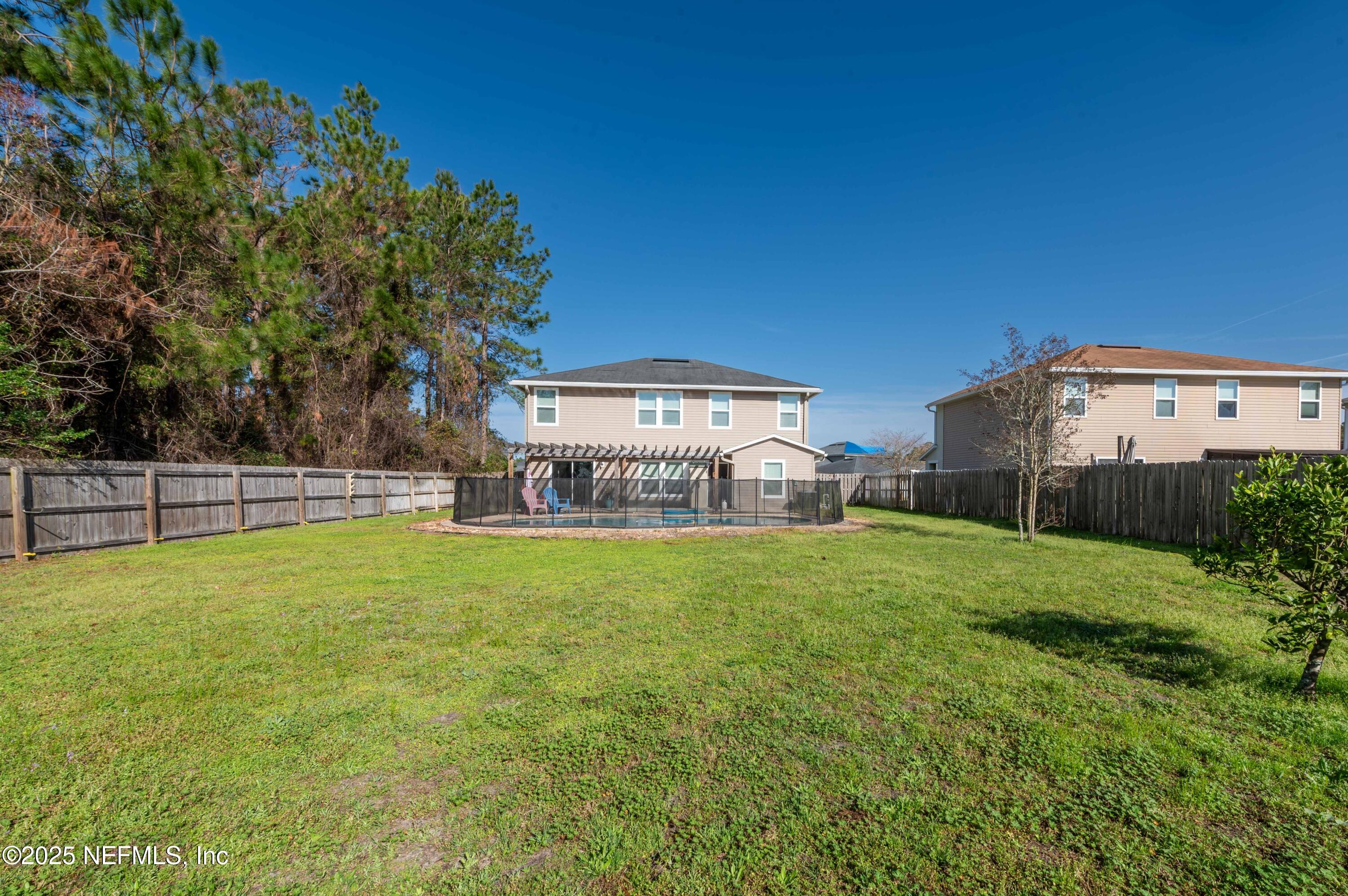77041 Cobblestone Drive Yulee, FL 32097 - Photo 20 of 23 a view of a house with backyard and a garden