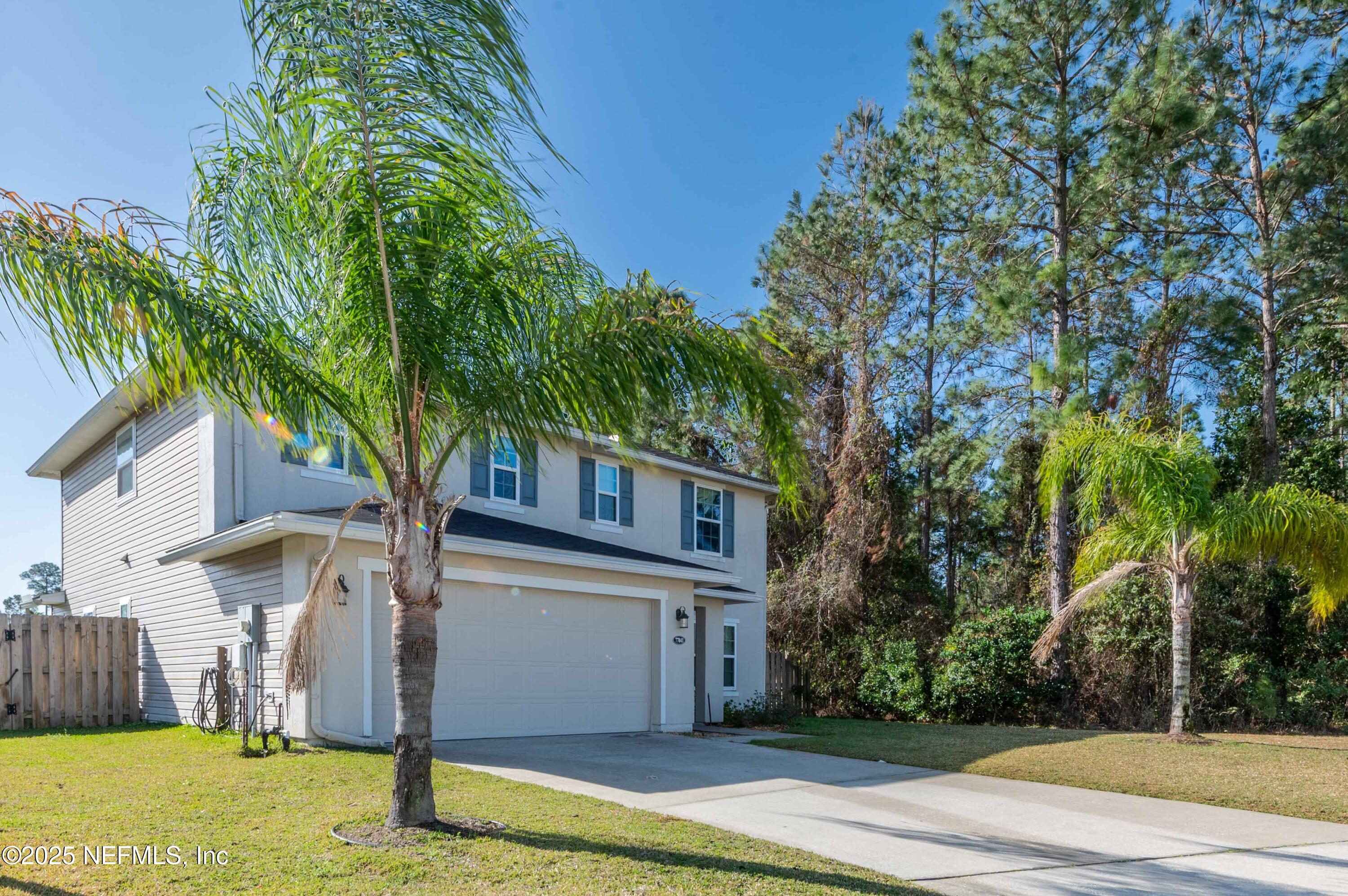 77041 Cobblestone Drive Yulee, FL 32097 - Photo 2 of 23 a front view of house with yard and trees