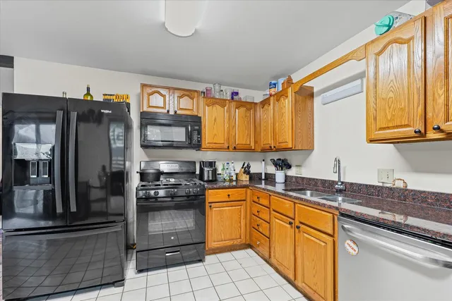 a kitchen with stainless steel appliances granite countertop a stove a sink and a refrigerator