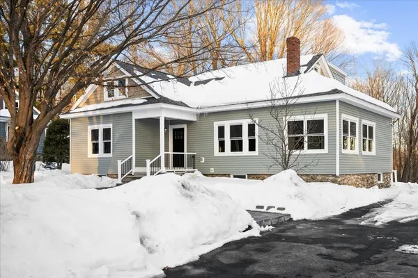 a view of a white house with a yard covered in snow
