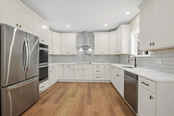 a kitchen with white cabinets stainless steel appliances and sink