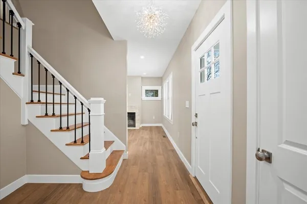 a view of a hallway with wooden floor and staircase